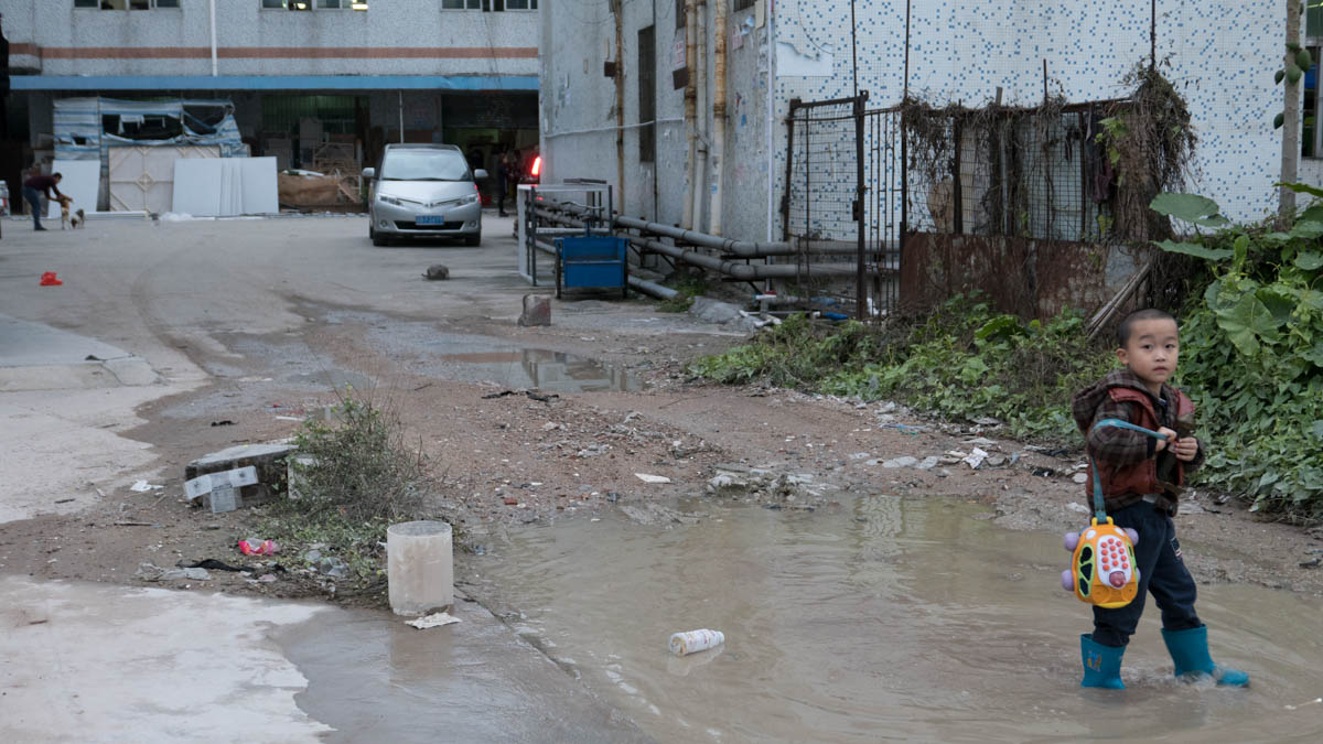 A child plays outside near the factory